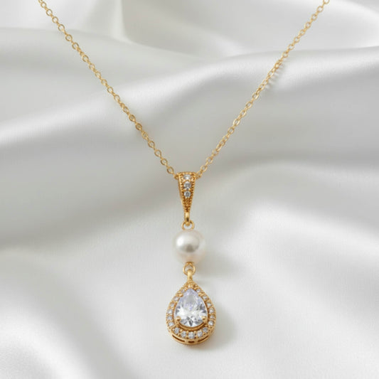 Dainty freshwater pearl teardrop pendant necklace on white satin background