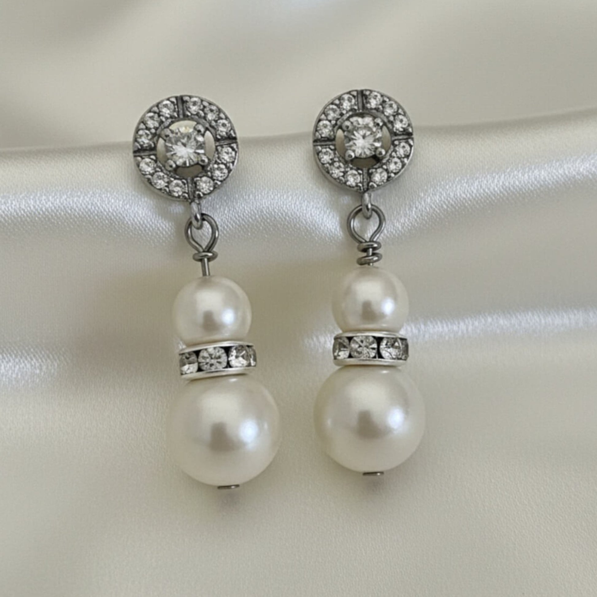 Close-up of pearl and crystal double drop earrings held in hand, elegant bridal jewellery for Australian weddings.