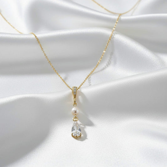 Bridal Gold necklace with a pendant on a white fabric background