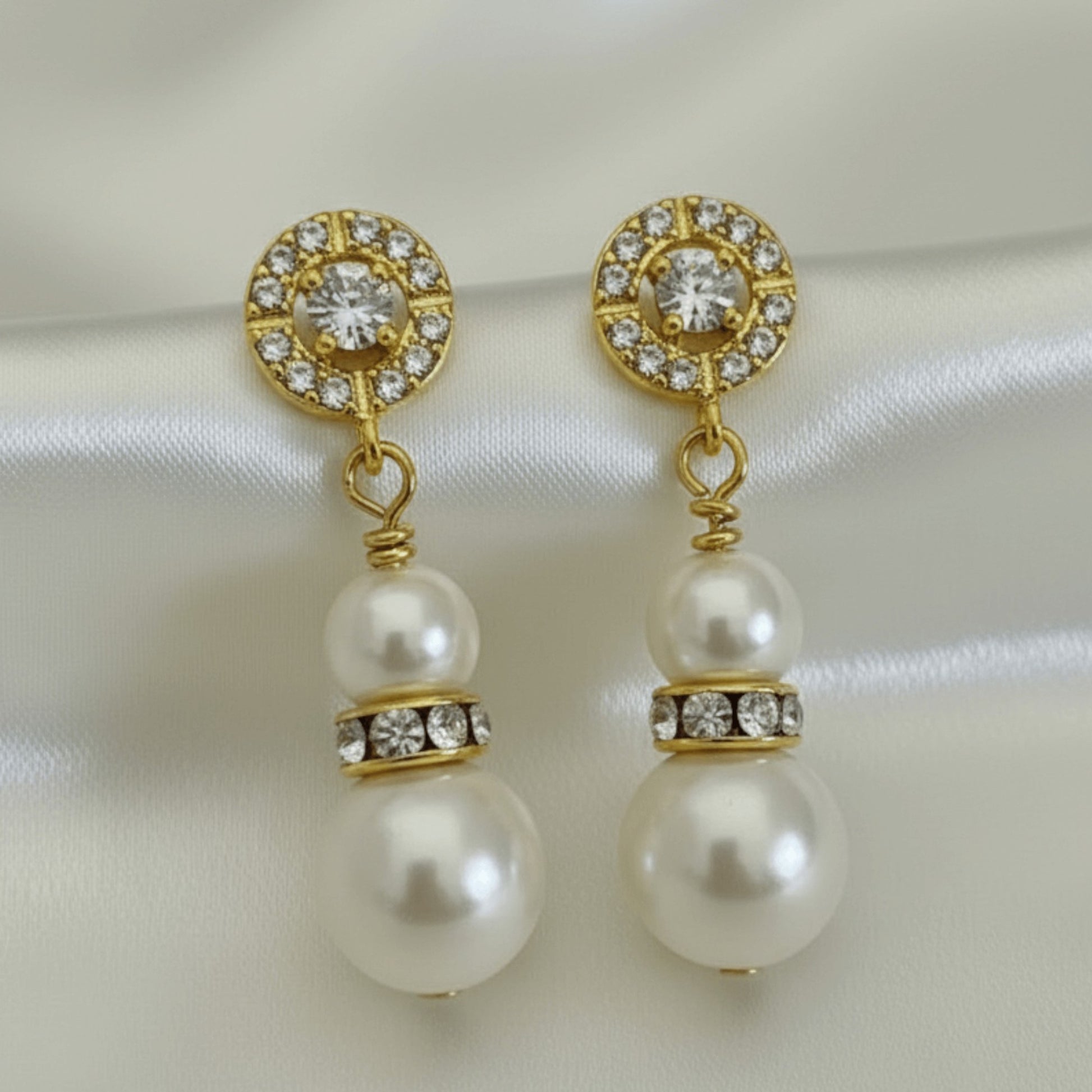  pearl drop earrings with crystal halo detail, photographed on soft neutral background for bridal styling.