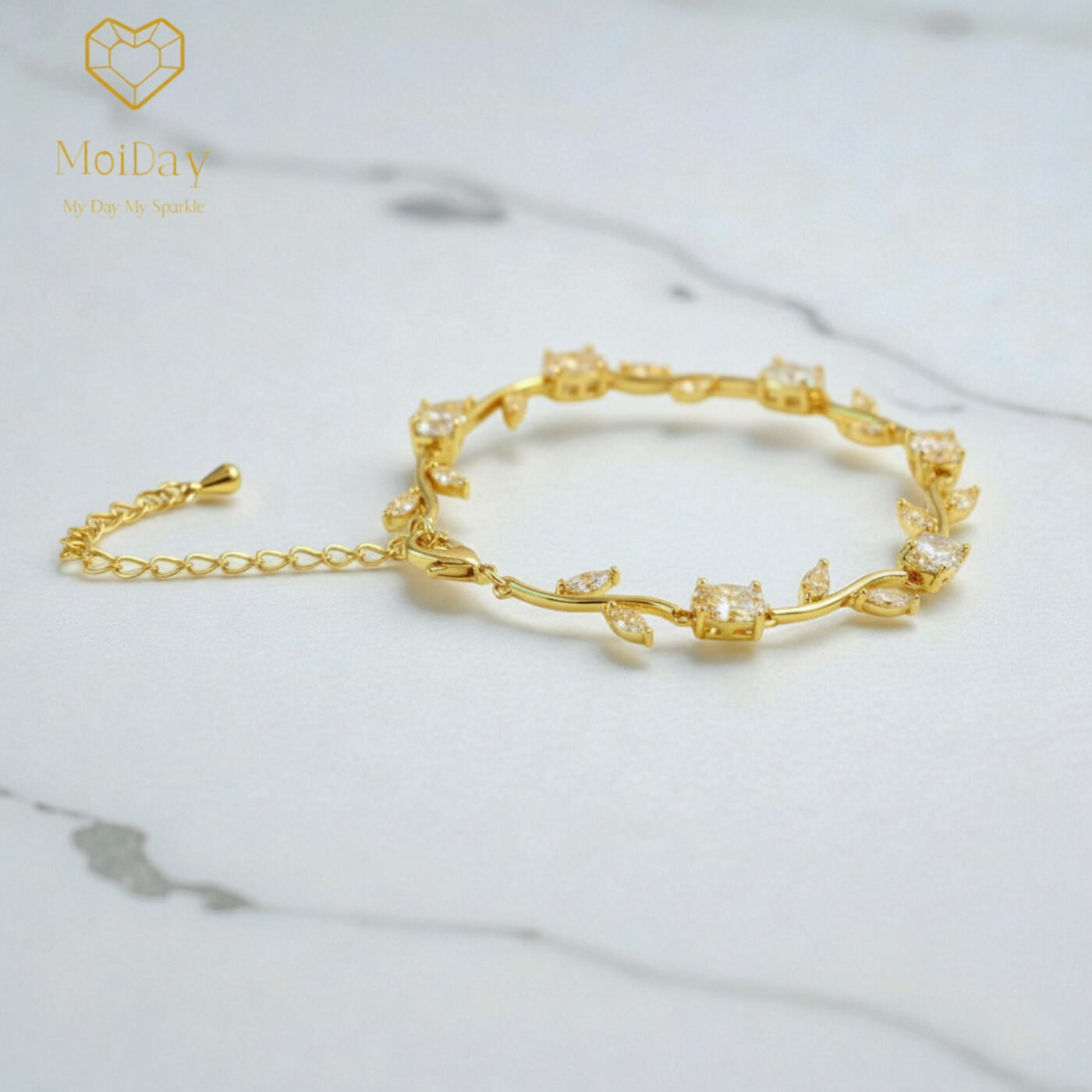 Moiday wedding bracelet with vine silhouette and crystal embellishments styled on a soft neutral surface.