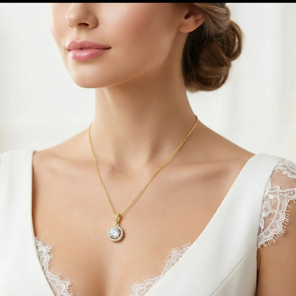 Gold halo pendant necklace styled with deep red satin gown, elegant updo and warm indoor lighting