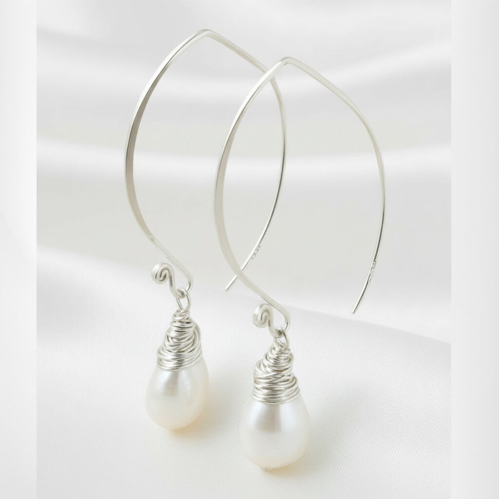 sterling silver S925 freshwater pearl drop earrings photographed on white satin background