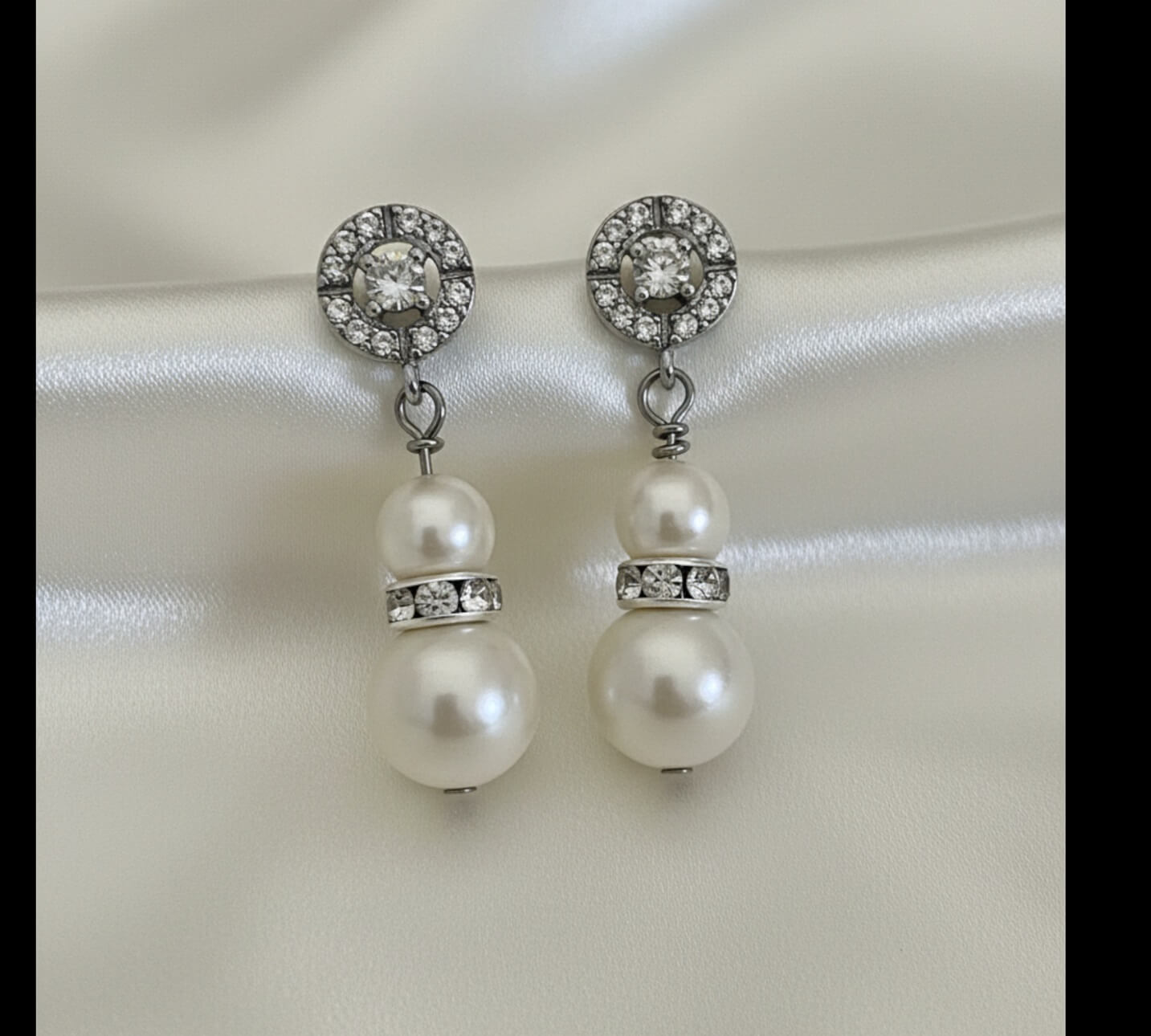 Gold and pearl drop earrings photographed on satin fabric background