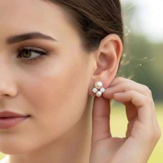 Side-profile bridal shot highlighting pearl and zirconia stud earrings in natural light.