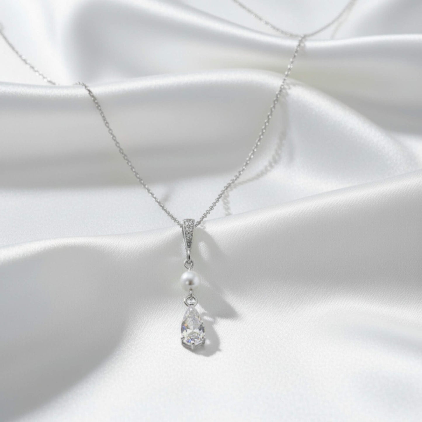 Pearl and crystal necklace on a white fabric background