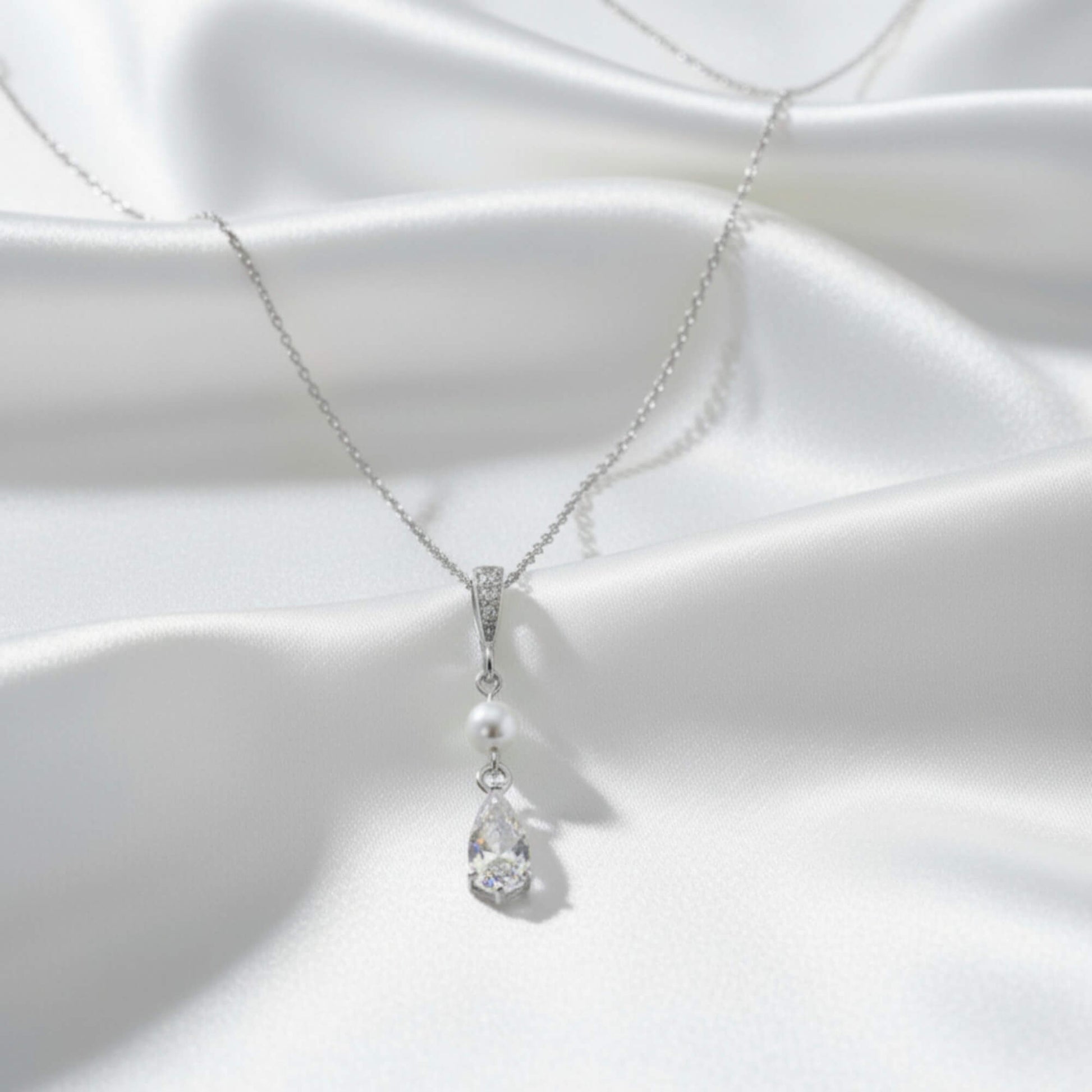 Pearl and crystal necklace on a white fabric background