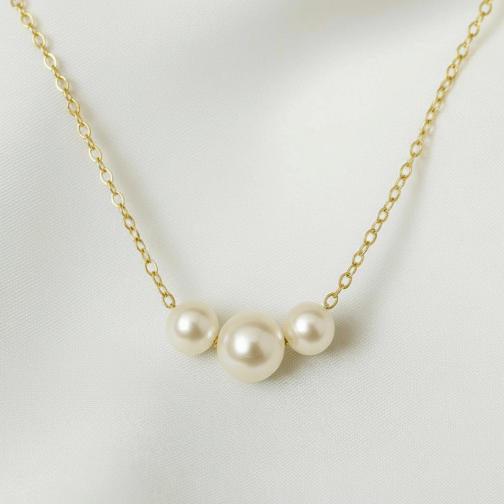 Pearl necklace with gold chain on a light gray background