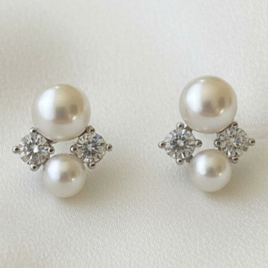 Pair of pearl earrings with small diamonds on a light background