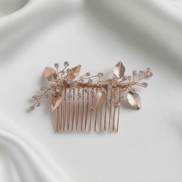 Rose gold botanical hairpiece arranged in an airy bridal flatlay with soft light.