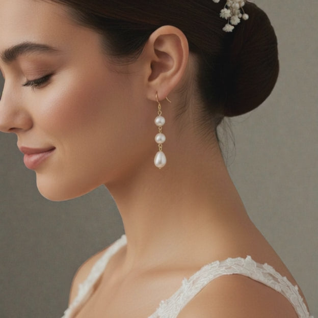 bride wearing gold pearl drop earrings with soft, natural lighting.