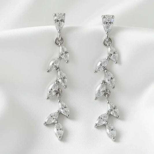 Pair of silver earrings with clear gemstones on a white background