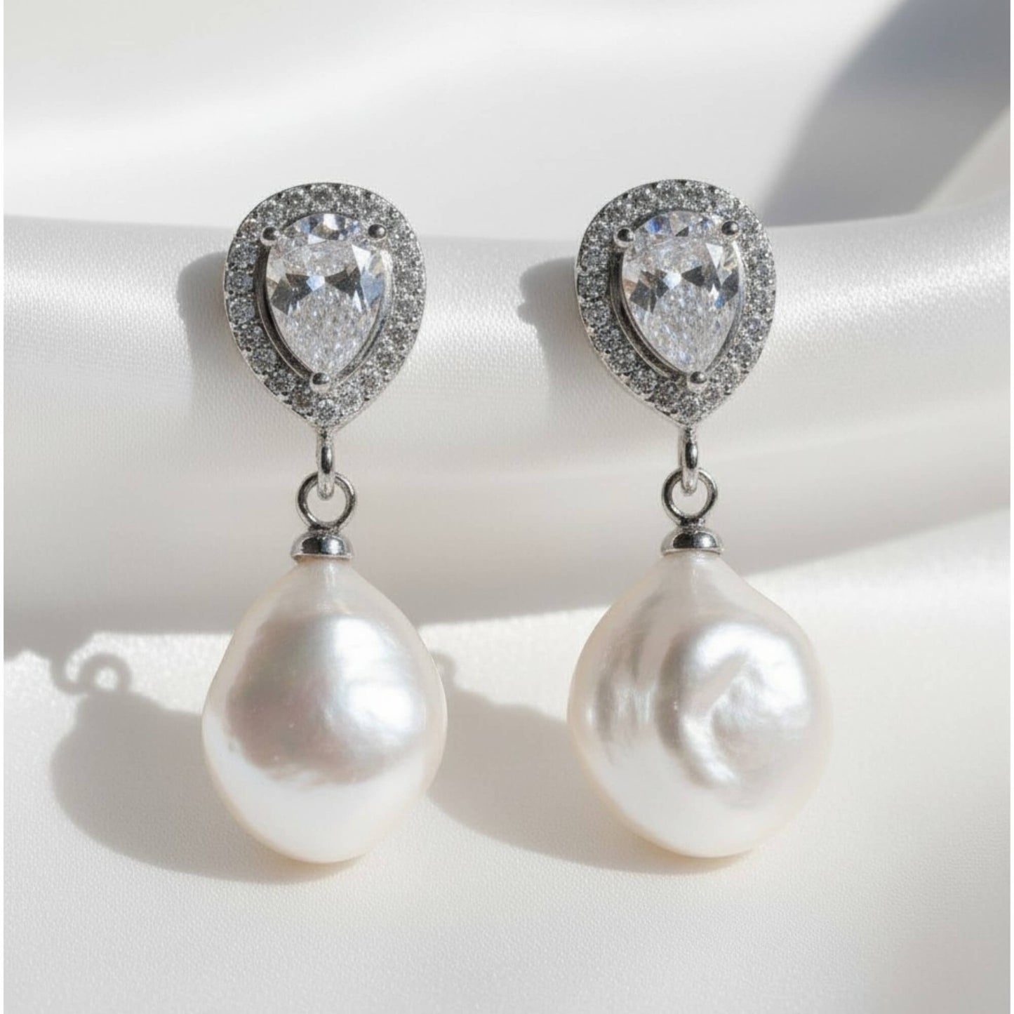 Pearl earrings with heart-shaped gemstones on a white background