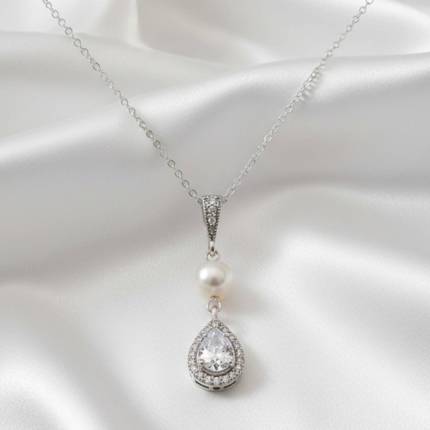 Luxury bridal pearl pendant necklace displayed on soft satin fabric