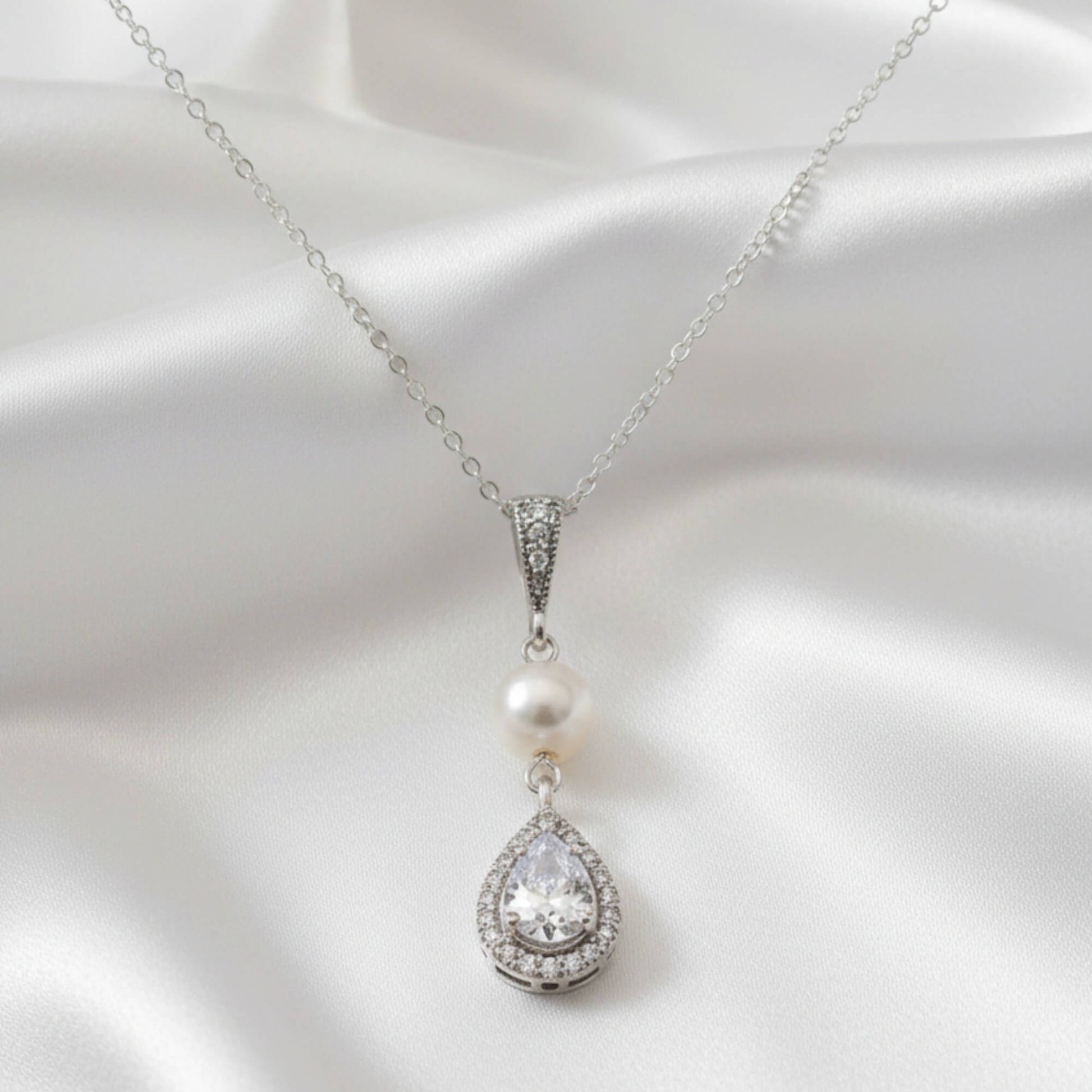 Luxury bridal pearl pendant necklace displayed on soft satin fabric