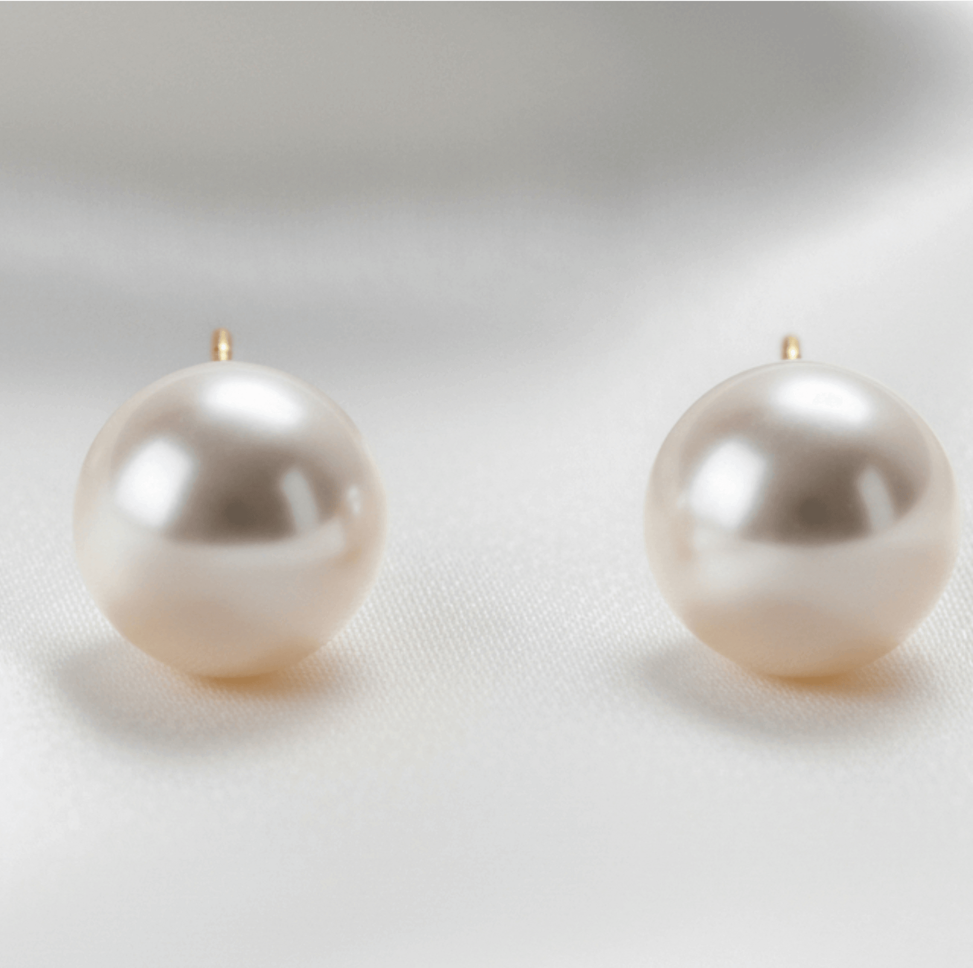 Pair of pearl earrings on a light gray background